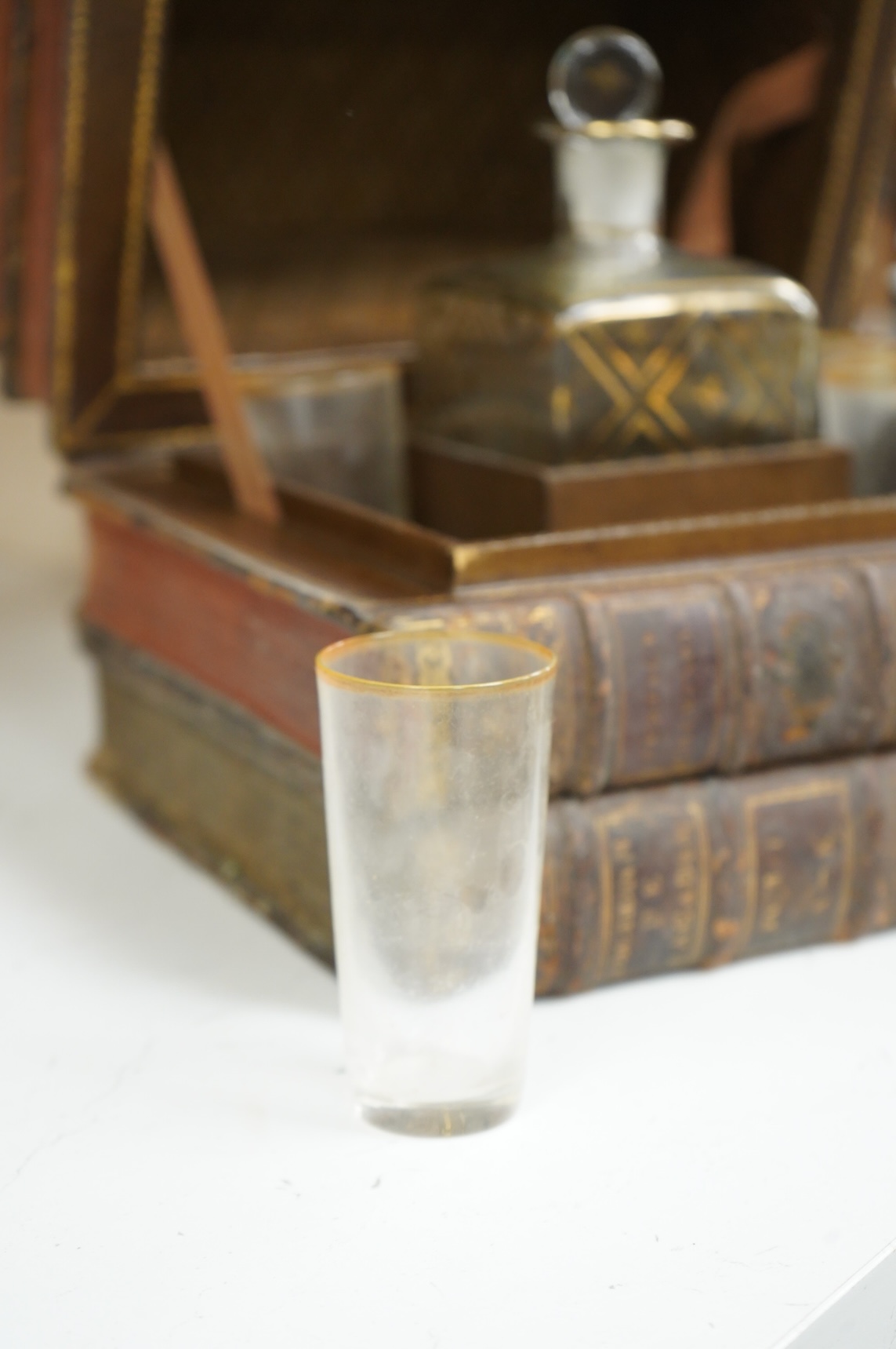 A novelty stack of books liqueur set, the contents including, decanter with stopper and five glasses, 26cm wide x 23cm high